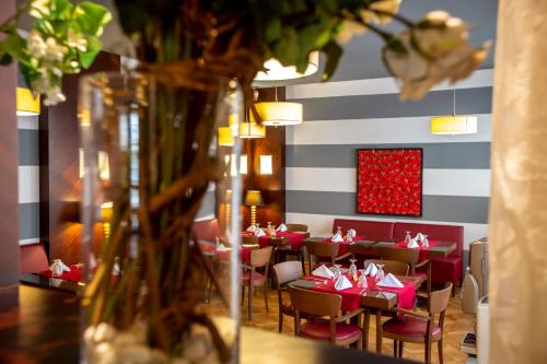a restaurant with red tables and chairs and a striped wall at Hotel Atlantic Agdal in Rabat