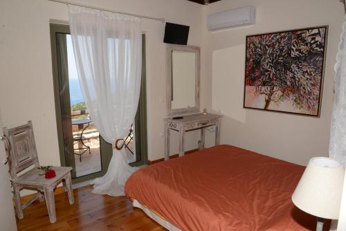 a bedroom with a bed and a large window at Dio Guesthouses in Leonidion