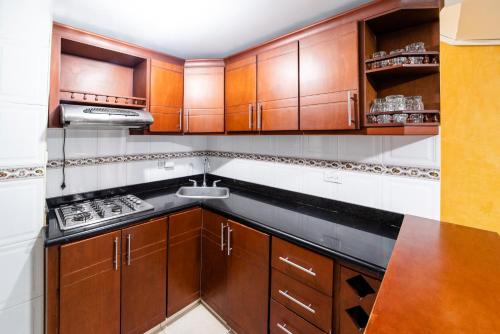 サンタ・マルタにあるApartamentos DNR 201B Rodadero Palanoaのキッチン(木製キャビネット、コンロ付)