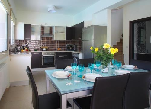 a kitchen with a table with plates and flowers on it at Michelle 8 in Protaras