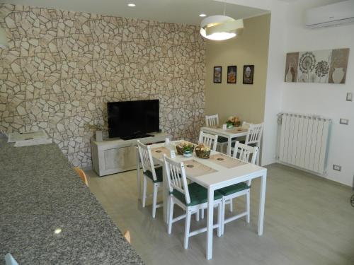 salon ze stołem, krzesłami i telewizorem w obiekcie A Casa di Anna - Locazione Turistica - w mieście Matera