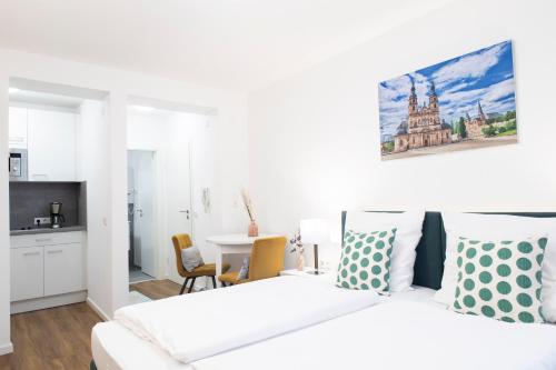 a white bedroom with a bed and a table at Leben im Herzen von Fulda in Fulda