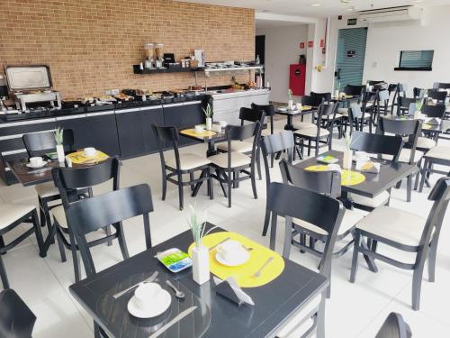 a dining room with tables and chairs in a restaurant at Pinda Palace Hotel in Pindamonhangaba