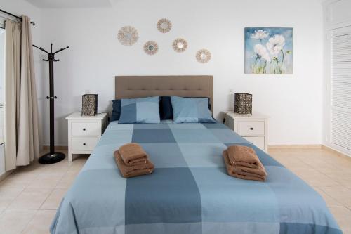 a bedroom with a large bed with towels on it at Maximilian House-Duplex vista al mar en complejo con piscina in Puerto del Carmen