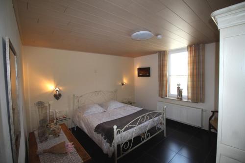1 dormitorio con cama y ventana en Het Rustplekje, en Alveringem