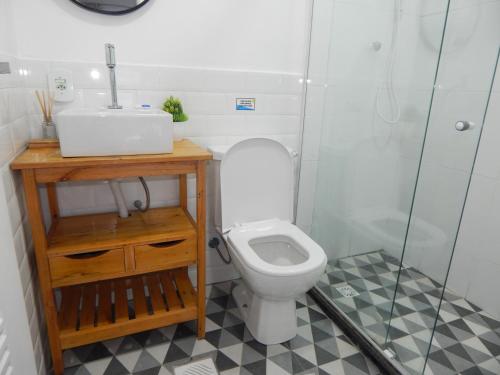 a bathroom with a toilet and a sink and a shower at Varandas da Praia do Forte - Apartamento frente ao Mar in Cabo Frio