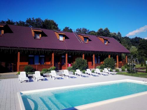 a house with a pool and chairs and a building at Karpatska Forel in Svalyava