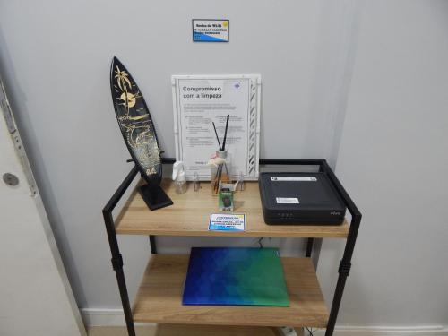a desk with a laptop and a board on it at Varandas da Praia do Forte - Apartamento frente ao Mar in Cabo Frio