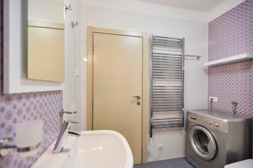 a bathroom with a sink and a washing machine at Villa Grdelina in Supetar