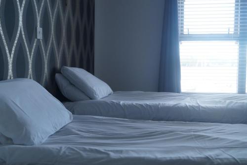 two beds with white sheets and pillows in a bedroom at The Narrows in Portaferry