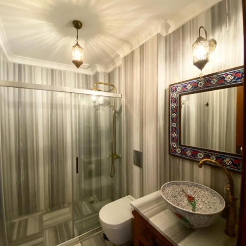 a bathroom with a sink and a toilet and a mirror at Villa Ephesus Hotel in Kusadası