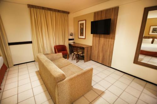a hotel room with a couch and a bed at Holiday Inn Fortaleza by IHG in Fortaleza
