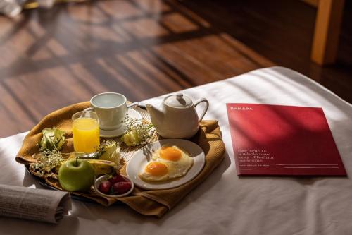 a breakfast plate with eggs and coffee and fruit on a table at Ramada Addis, Addis Ababa in Addis Ababa