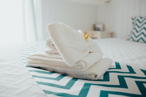 uma pilha de toalhas sentadas em cima de uma cama em Camy House em Nazaré