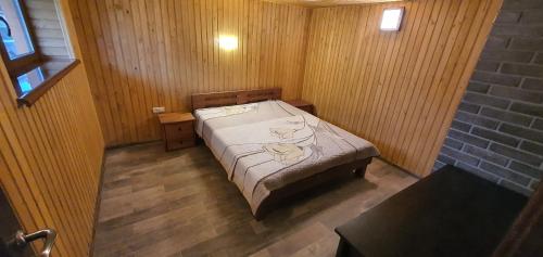 NovoselitsaにあるVilla Ortusの木製の部屋にベッド1台が備わるベッドルーム1室があります。