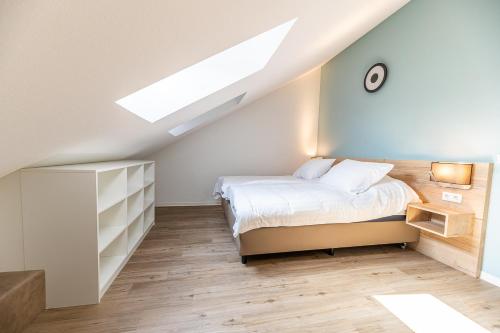 - une chambre mansardée avec un lit et une lucarne dans l'établissement Boutique resort Schaardijk vakantieappartement, à Scharendijke