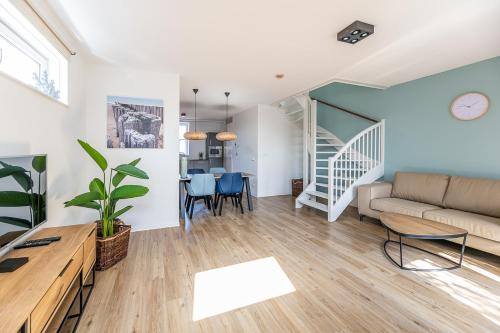 ein Wohnzimmer mit Sofa und Tisch in der Unterkunft Boutique resort Schaardijk vakantieappartement in Scharendijke