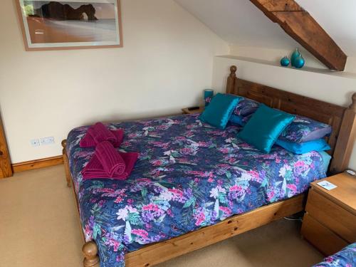 a bedroom with a bed with blue pillows at Mallows Cottage in Sherborne