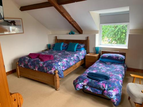a bedroom with two beds and a window at Mallows Cottage in Sherborne
