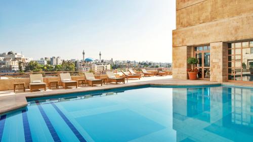a swimming pool on the roof of a building at Grand Hyatt Amman in Amman