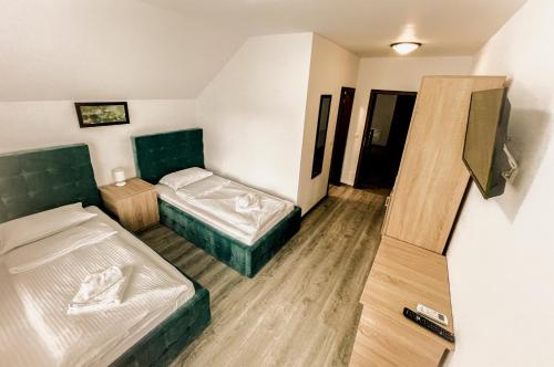 a small room with two beds and a closet at Pensiunea Balkan in Gornea