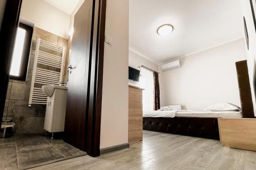 a small room with a bed and a bathroom at Pensiunea Balkan in Gornea