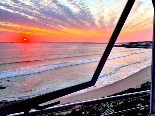 a view from a window of a beach at sunset at Crystal Lagoon Lodge in Langebaan