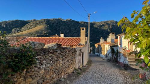 un callejón en un pueblo con montañas en el fondo en My Grandmas A casa das avós, en Vale de Figueira