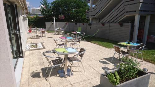 a group of tables and chairs on a patio at Campanile Tours Sud - Chambray-Les-Tours in Chambray-lès-Tours