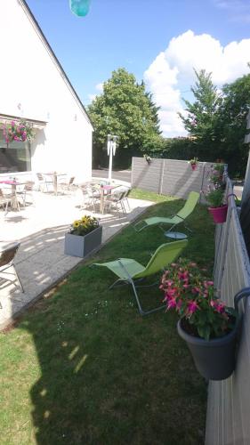 a yard with some flowers in pots on the grass at Campanile Tours Sud - Chambray-Les-Tours in Chambray-lès-Tours