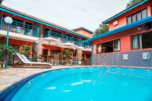 a swimming pool in front of a house at Pousada Morada da Praia in Ubatuba