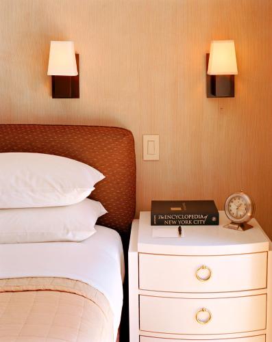 a bedroom with a bed and a clock on a night stand at City Club Hotel in New York