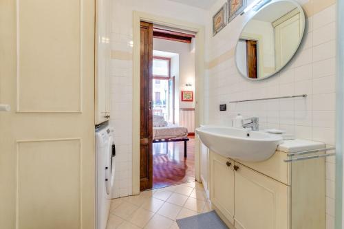 een witte badkamer met een wastafel en een spiegel bij Easylife - Classic Flat in Corso Como in Milaan