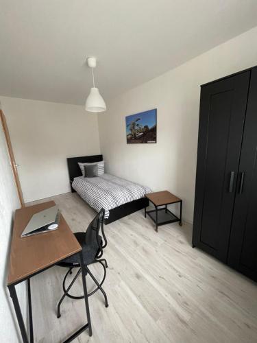 a bedroom with a bed and a desk with a laptop at Modernes Business Apartment für Geschäftsreisende, Monteure, Handwerker in Burgneudorf