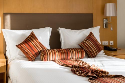 a bed with two pillows and a blanket on it at Ramada Addis, Addis Ababa in Addis Ababa