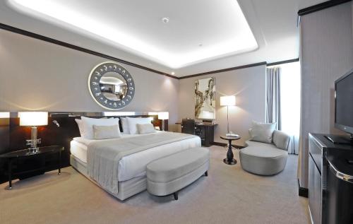 1 dormitorio con 1 cama blanca grande y TV en Crowne Plaza Bursa Convention Center & Thermal Spa, an IHG Hotel en Bursa