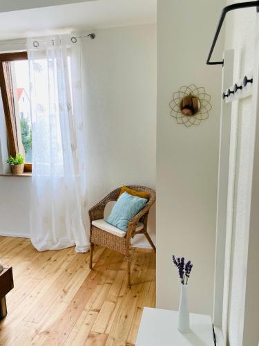a wicker chair in a living room with a window at das Höfchen Stadecken in Stadecken-Elsheim