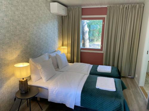 Habitación de hotel con cama grande y ventana en Kaunissaaren Maja en Kotka