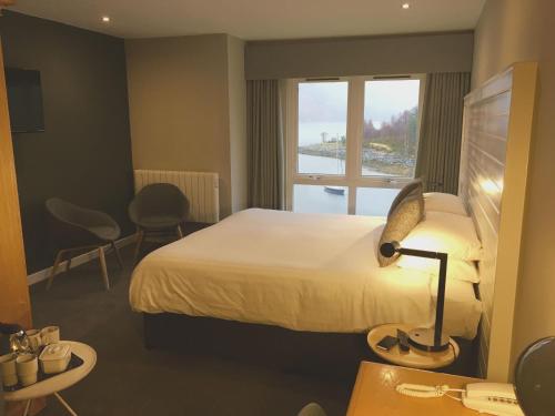 um quarto de hotel com uma cama e uma janela em The Isles of Glencoe Hotel em Glencoe