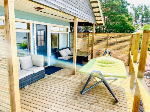 a wooden deck with a chair and a swing at Kaunissaaren Maja in Kotka
