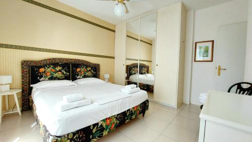 - une chambre avec un grand lit et un grand miroir dans l'établissement Foscolo POOL apartment, à Bardolino