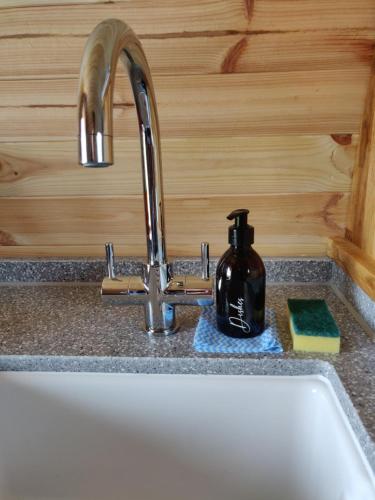 a sink with a soap dispenser sitting next to a kitchen sink at Braeview Glamping in Eyemouth