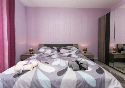1 dormitorio con 1 cama grande y paredes moradas en Apartment Lapad Bay, en Dubrovnik