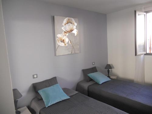 une chambre avec deux lits et un tableau au mur dans l'établissement Les Terrasses du Ventoux, à Mollans-sur-Ouvèze