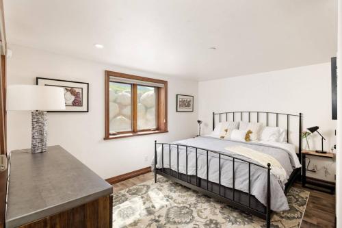 a bedroom with a bed and a window and a table at Chaparral Aspen Ranch Cabin in Woody Creek