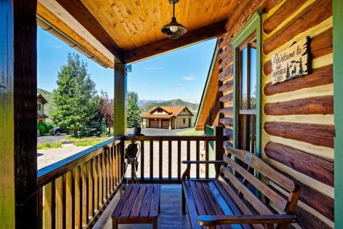 a porch of a cabin with benches on it at Chaparral Aspen Ranch Cabin in Woody Creek