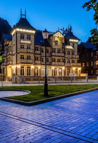 a large building with a street light in front of it at Hotel Willa Tatrzańska in Krynica Zdrój
