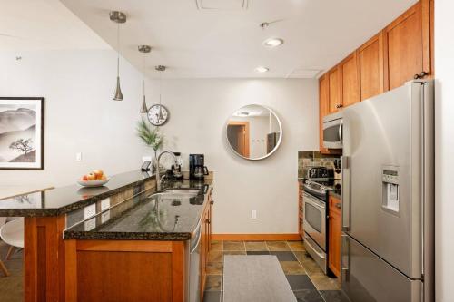 a kitchen with a stainless steel refrigerator and wooden cabinets at Capitol Peak A3209 in Snowmass Village