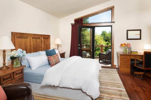 a bedroom with a bed and a desk and a window at Top of Lemond Home in Snowmass Village
