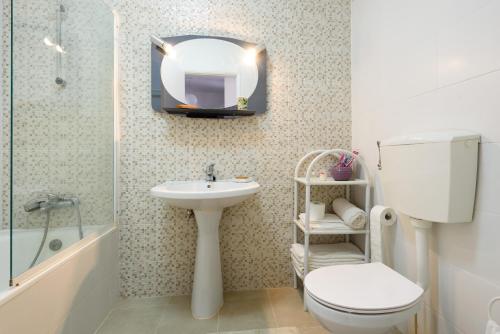 bagno con servizi igienici, lavandino e specchio di Cister House ad Alcobaça